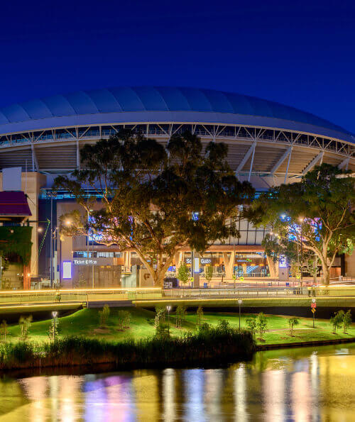 Adelaide Oval illuminated at dusk with River Torrens reflections