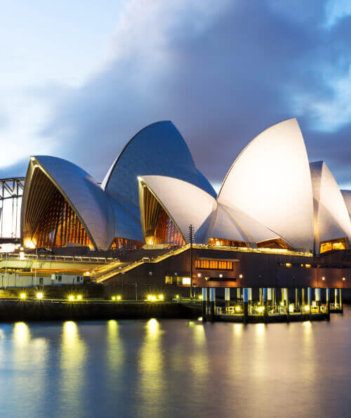 Sydney Opera House illuminated at dusk on the harbour